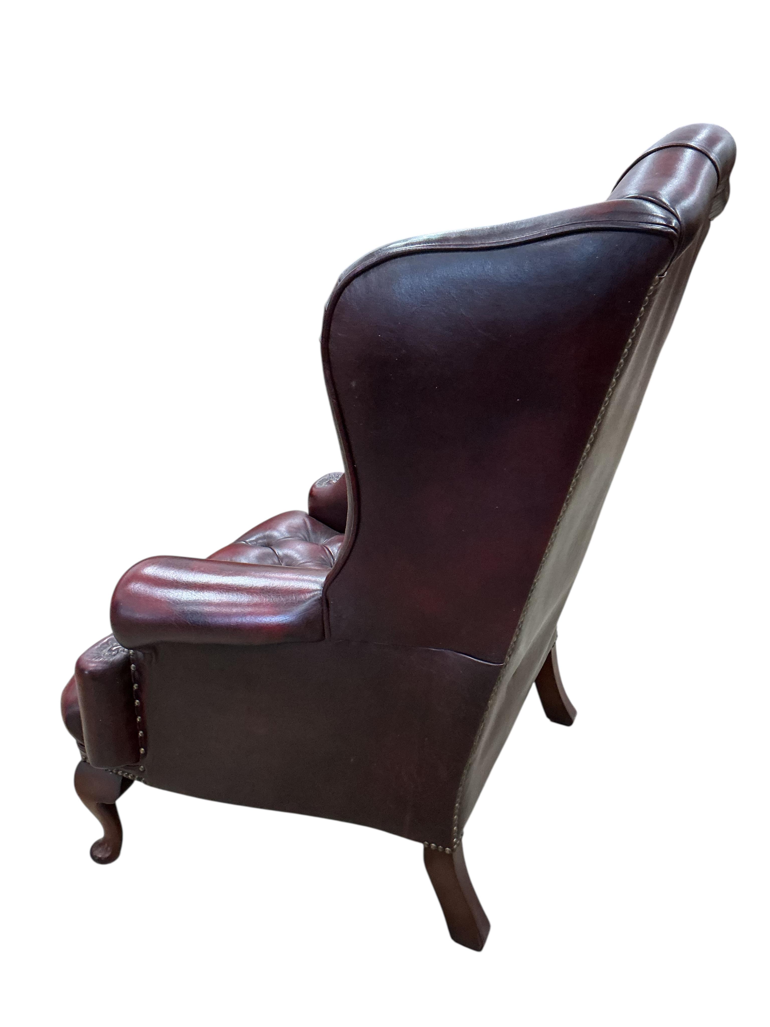 A pair of reproduction buttoned burgundy leather wing armchairs, width 82cm, depth 70cm, height 104cm